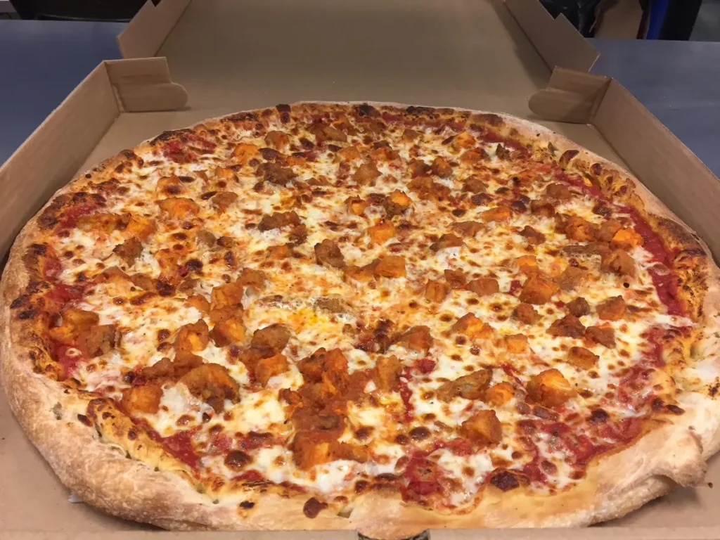 Buffalo chicken pizza covered in breaded chicken tossed in mild sauce over a cheese pizza