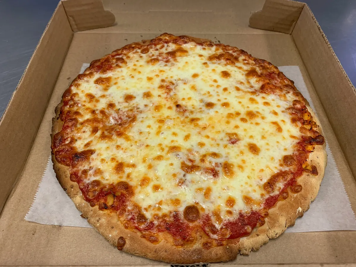 Small cauliflower crust cheese pizza with sauce and melted mozzarella in a pizza box