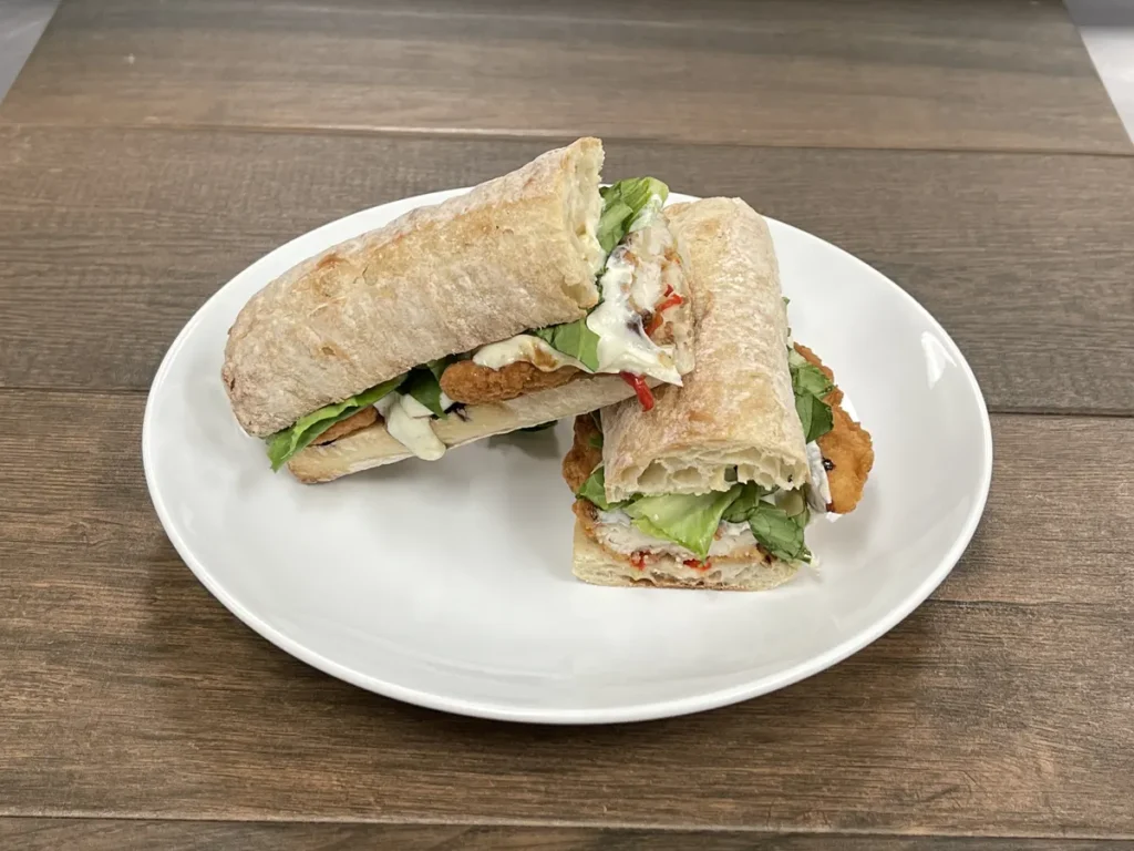 Chicken cutlet sub with fresh mozzarella, roasted red peppers and romaine on a baguette
