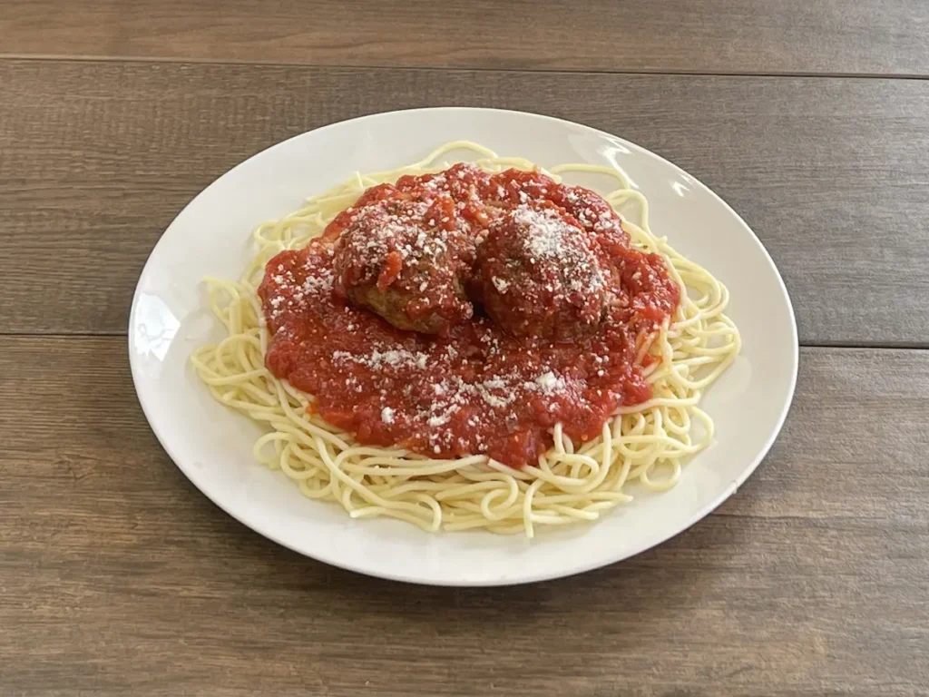 Spaghetti with two meatballs, marinara and parmesan